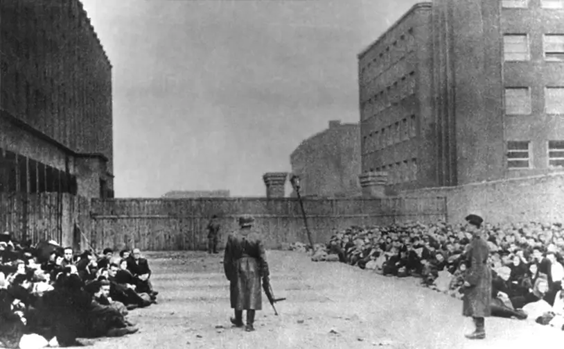 Jews in the Warsaw Ghetto waiting for deportation to a concentration camp under the supervision of German soldiers.