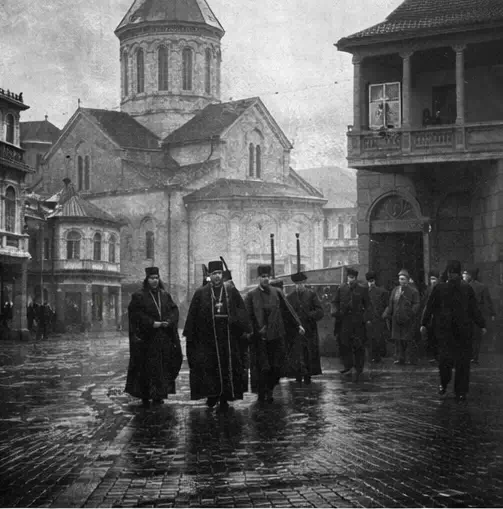 Чекисты арестовывают священников на фоне церкви.