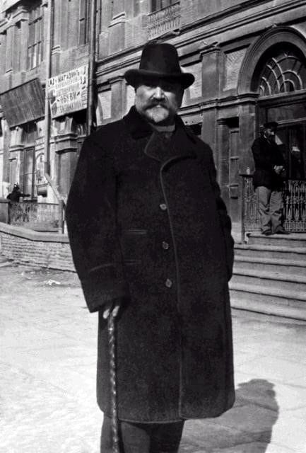 In the photo, Ilia Chavchavadze is standing on a street in Tbilisi holding a cane.