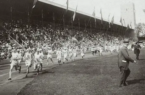 Начало марафона 1912 года в Стокгольме, когда бегуны сразу после старта стараются занять лидирующие позиции.
