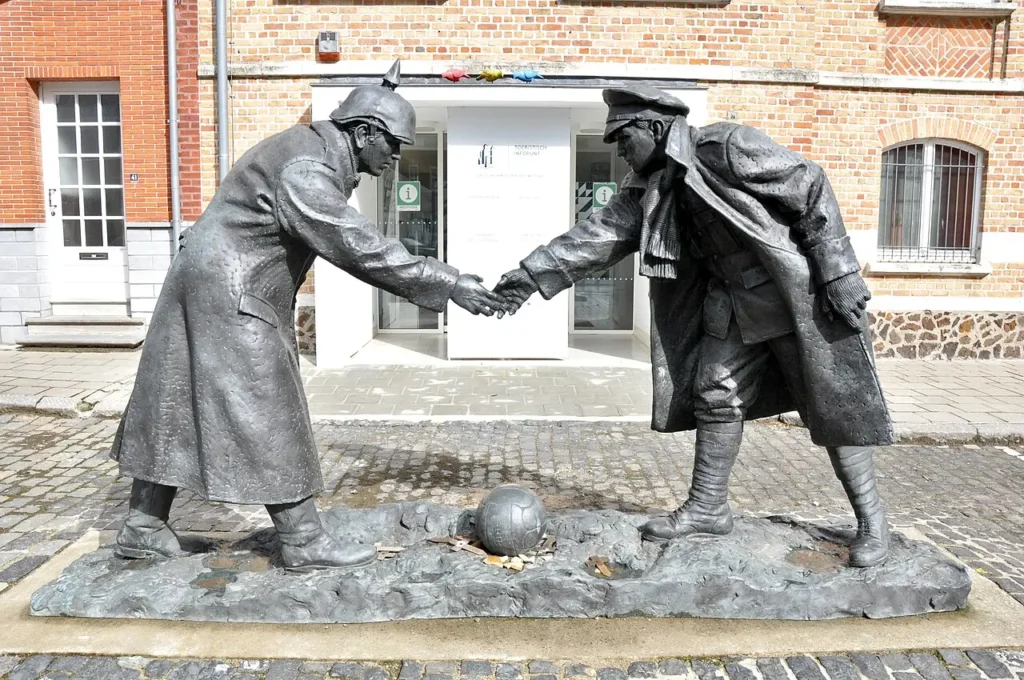 Memorial sculpture in Belgium commemorating the 1914 Christmas Truce, depicting the historic meeting between German and British soldiers as a symbol of peace.