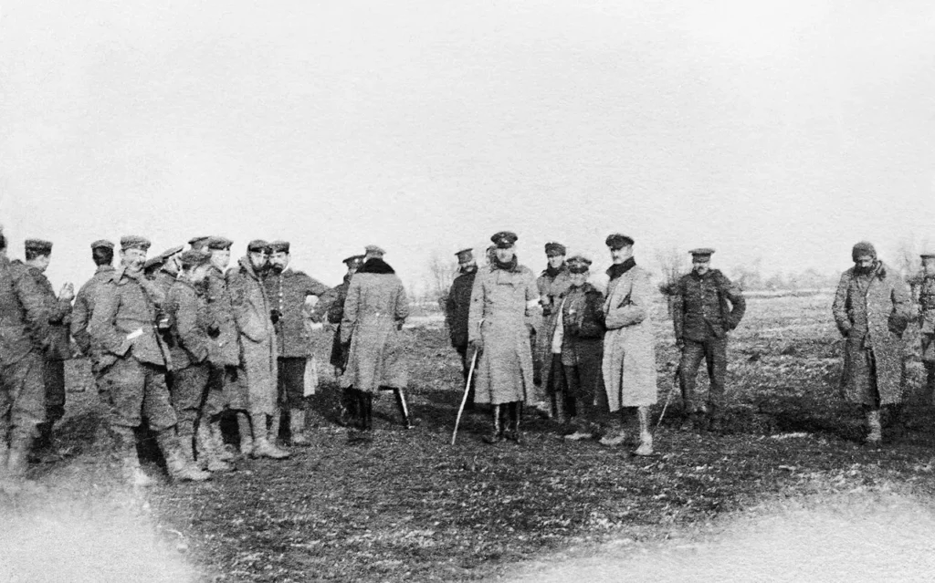 German and British soldiers meeting on the front lines during the 1914 Christmas Truce in World War I, temporarily stopping the fighting.