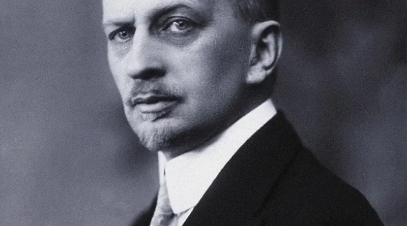 Black and white portrait photograph of Ivan Ilyin, the Russian conservative philosopher, wearing a suit and tie, looking directly into the camera.